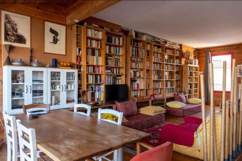 una sala de estar con una mesa y algunas estanterías de libros en Large duplex house with terrace in Bordeaux, en Burdeos