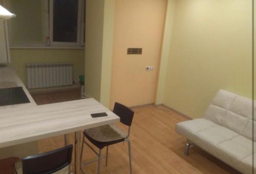 sala de estar con mesa, sillas y sofá en VIP apart 373, en Tiflis