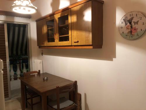 een keuken met een tafel en een klok aan de muur bij Small flat with everything near metro in Piraeus