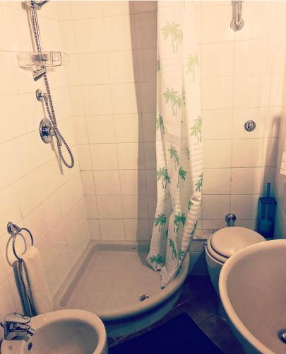 a bathroom with a tub and a toilet and a shower curtain at Casetta incantevole Genzano di Roma in Genzano di Roma
