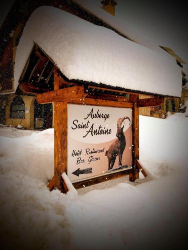 a sign in the snow in front of a building at Auberge Saint Antoine in Pelvoux