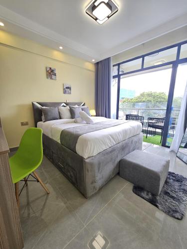 a bedroom with a large bed and a large window at Cosynook Home Valley Heights in Nairobi