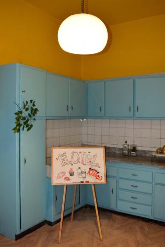 una cocina con armarios azules y un cartel en una mesa en El Otel The Hotel, en El Cairo