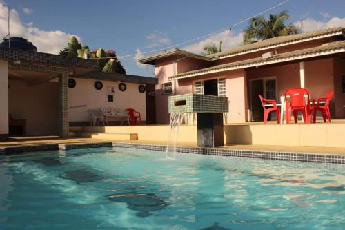 una piscina con una fuente frente a una casa en Chacara nossa senhora aparecida en Socorro