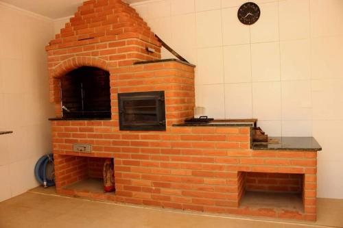 un horno de ladrillo en una habitación con un reloj en la pared en Chacara nossa senhora aparecida en Socorro