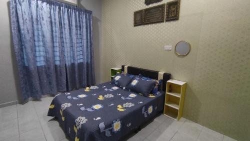 een slaapkamer met een bed met een blauw dekbed bij Homestay Ara Kaseh in Mersing