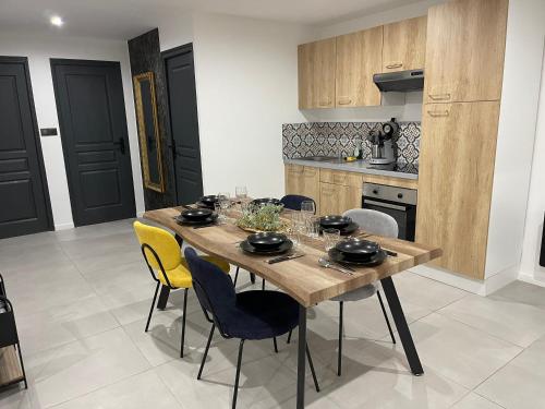 a kitchen with a wooden table and chairs at Le Baroque - plain-pied - 3 chambres - Wi-fi in Lens