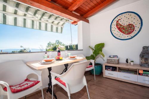 a dining room with a table and chairs and a window at Apartment Opatija with Garden and Seaview in Opric