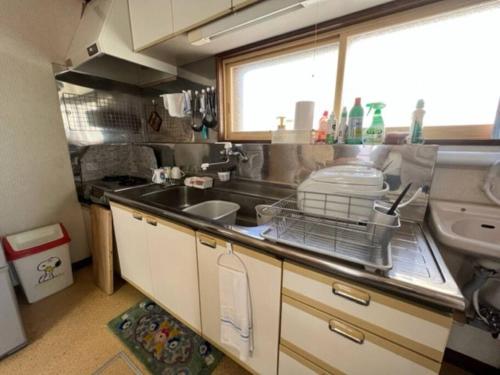 a small kitchen with a sink and a window at 静かな田舎の一軒家 ご家族友達観光大型スキー場近郊 in Mikage