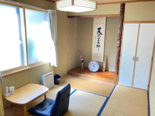 a room with a table and a chair and a window at 静かな田舎の一軒家 ご家族友達観光大型スキー場近郊 in Mikage