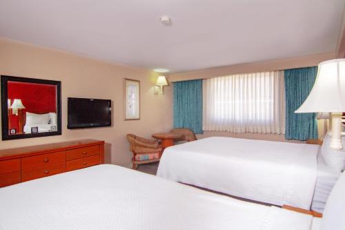 een hotelkamer met 2 bedden en een televisie bij ARMIDA EXPRESS in Guaymas