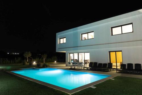 a swimming pool in front of a house at night at Casa dos Mirtilos Duke T8 in Celorico de Basto