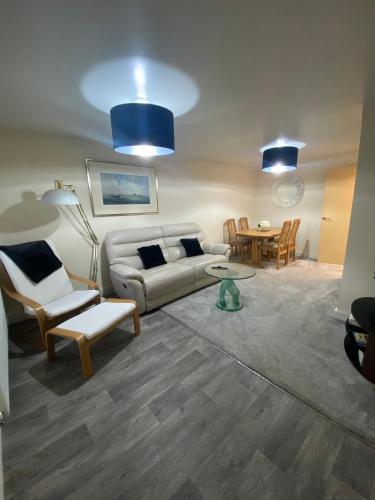 a living room with a couch and chairs and a table at Lovely 2 bed apartment in Crosby in Liverpool
