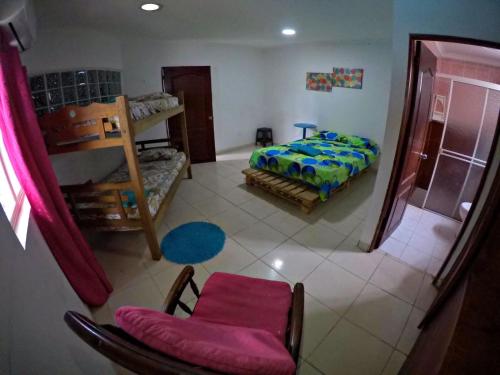 1 dormitorio con 1 cama y 1 silla en una habitación en Nahimara Champeta Hostel, en Cartagena de Indias