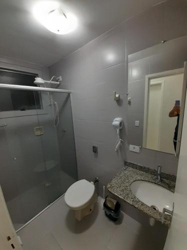 uma casa de banho com um chuveiro, um WC e um lavatório. em Apartamento no centro de Cuiabá a 4 km do aeroporto em Cuiabá