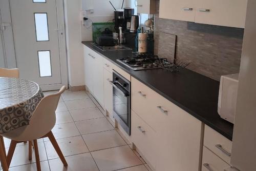 une cuisine avec une table et une cuisinière four supérieur dans l'établissement Gîte Les Flôreaux appartement, à Die