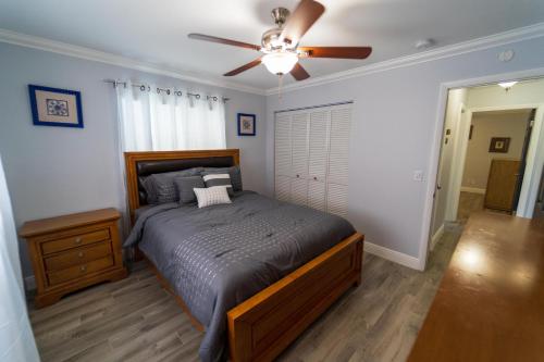 1 dormitorio con 1 cama y ventilador de techo en Mt Irvine Luxe Pool Cottage/Close to Beach and Equestrian en Florida Gardens
