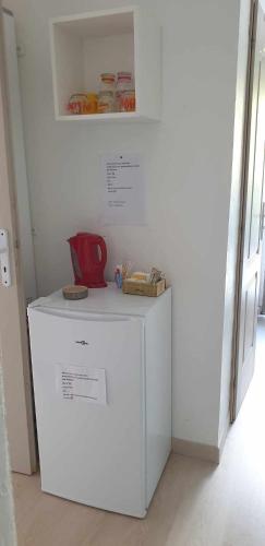 Elle comprend un réfrigérateur blanc avec une carafe rouge. dans l'établissement Chez Faby et José, à Avignon