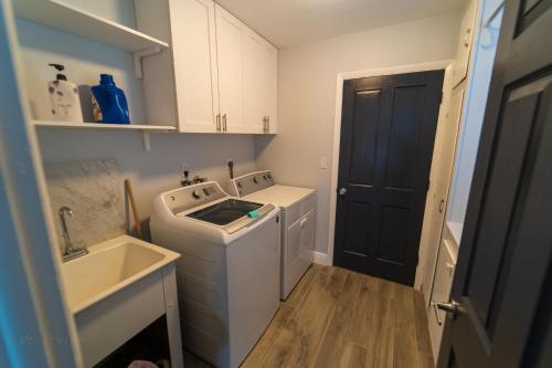 a small kitchen with a washing machine and a sink at Mt Irvine Luxe Pool Cottage/Close to Beach and Equestrian in Florida Gardens