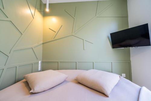 Cette chambre comprend un lit avec deux oreillers et une télévision. dans l'établissement Charmant T2 à proximité de Castellane - Le Bistrot, à Marseille