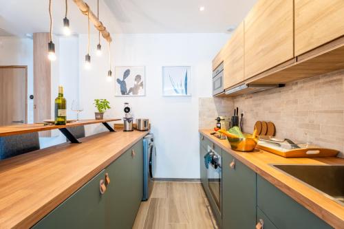 une cuisine avec des armoires bleues et des comptoirs en bois dans l'établissement Charmant T2 à proximité de Castellane - Le Bistrot, à Marseille