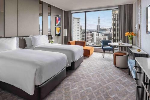 a hotel room with two beds and a large window at Cordis, Auckland by Langham Hospitality Group in Auckland