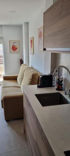 a living room with a couch and a kitchen at PEÑISMAR AZAHAR in Peniscola