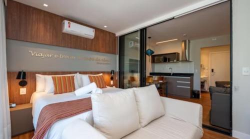 een slaapkamer met een groot wit bed en een bank bij Wanderlust Experience Hotel, Campos do Jordão in Campos do Jordão