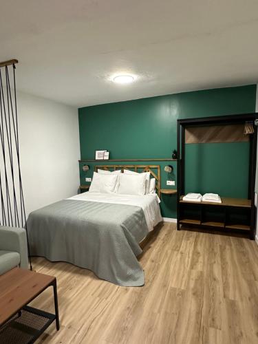 SlowHome Arcos في أركوس ديلا فرونتيرا: غرفة نوم بسرير كبير وجدار أخضر