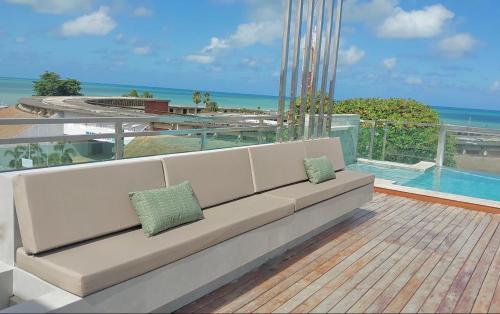 un sofá blanco sentado en la parte superior de un balcón con vistas al océano en Tambaú Israel Flat 417 en João Pessoa