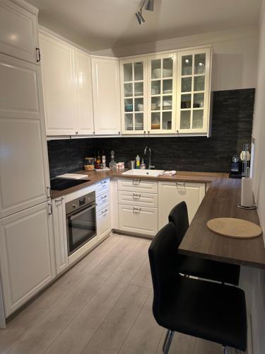 a kitchen with white cabinets and a black counter top at sjarmerende leilighet i hjertet av Oslo in Oslo