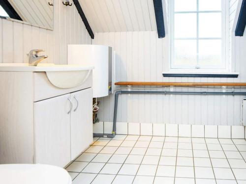 uma casa de banho branca com um lavatório e um frigorífico em Holiday Home Kræ em Klegod
