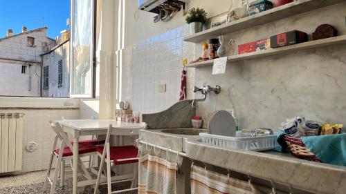 eine kleine Küche mit einem Waschbecken und einem Tisch in der Unterkunft B&B Ligustico in Genua