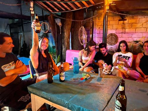 un gruppo di persone sedute intorno a un tavolo a bere birra di Nahimara Champeta Hostel a Cartagena de Indias