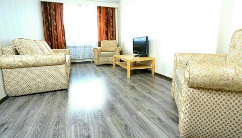 sala de estar con 2 sillas y TV en VIP apart 379, en Tiflis