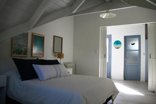 1 dormitorio con cama blanca y puerta azul en Loft de playa en Mar del Plata