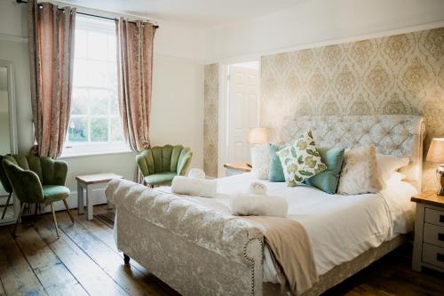 a bedroom with a large bed and two chairs at The Grove Ferry Inn in Chislet