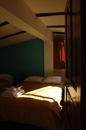 a bed in a room with a green wall at Casa D´Maria in Ollantaytambo