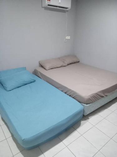 two beds sitting next to each other in a room at Orchid Homestay in Labuan
