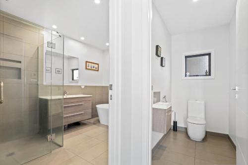 a bathroom with a shower and a toilet and a sink at Lake Tarawera Gem in Rotorua