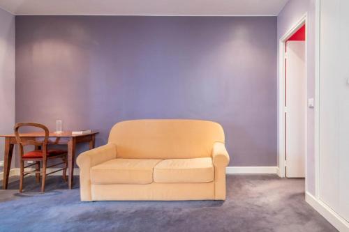 un salon avec une chaise et une table dans l'établissement Spacious 1 Bedroom Apartment in Paris, à Paris