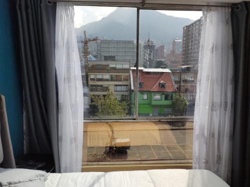 een slaapkamerraam met uitzicht op de stad bij apartasuite sector marly-chapinero-palermo in Bogota