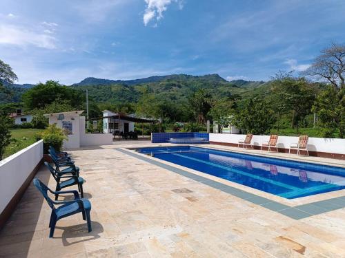a swimming pool with chairs sitting next to at Cabaña Sauce - Villeta in Villeta