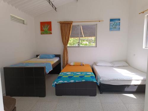 a room with two beds and a window at Cabaña Sauce - Villeta in Villeta