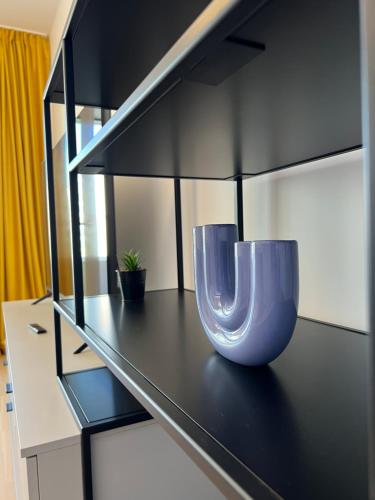 two purple vases sitting on a black shelf at C-entral Apartments Bucharest with Private Parking in Bucharest