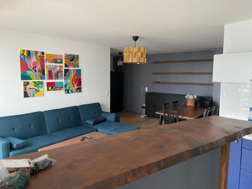 - un salon avec un canapé bleu et une table dans l'établissement 2 bedroom Apartment + Parking, à Saint-Denis