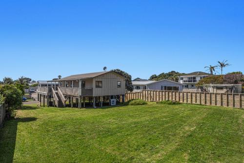 a yard with a house and a fence at The Sun Capsule - Ohope Beach Holiday Home in Ohope Beach