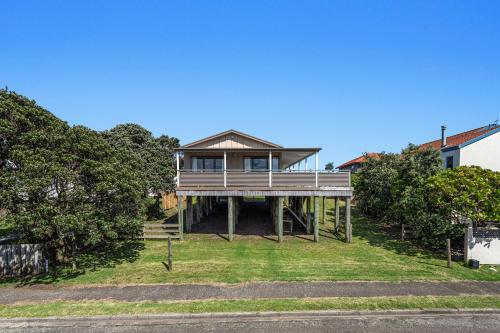 a house on top of a grassy hill at The Sun Capsule - Ohope Beach Holiday Home in Ohope Beach