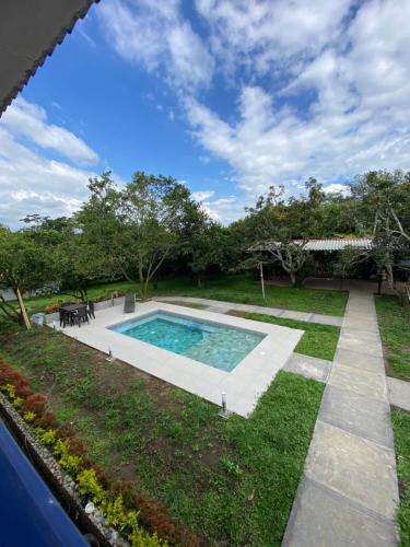 a backyard with a swimming pool and grass at Cabaña Quindiana - Excelente Ubicación in Montenegro