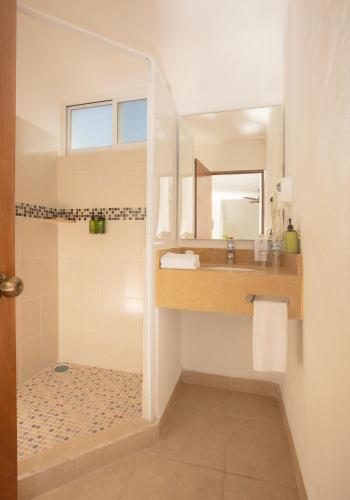 a bathroom with a shower and a sink and a mirror at Costa Club Punta Arena - Desayuno buffet incluido in Puerto Vallarta